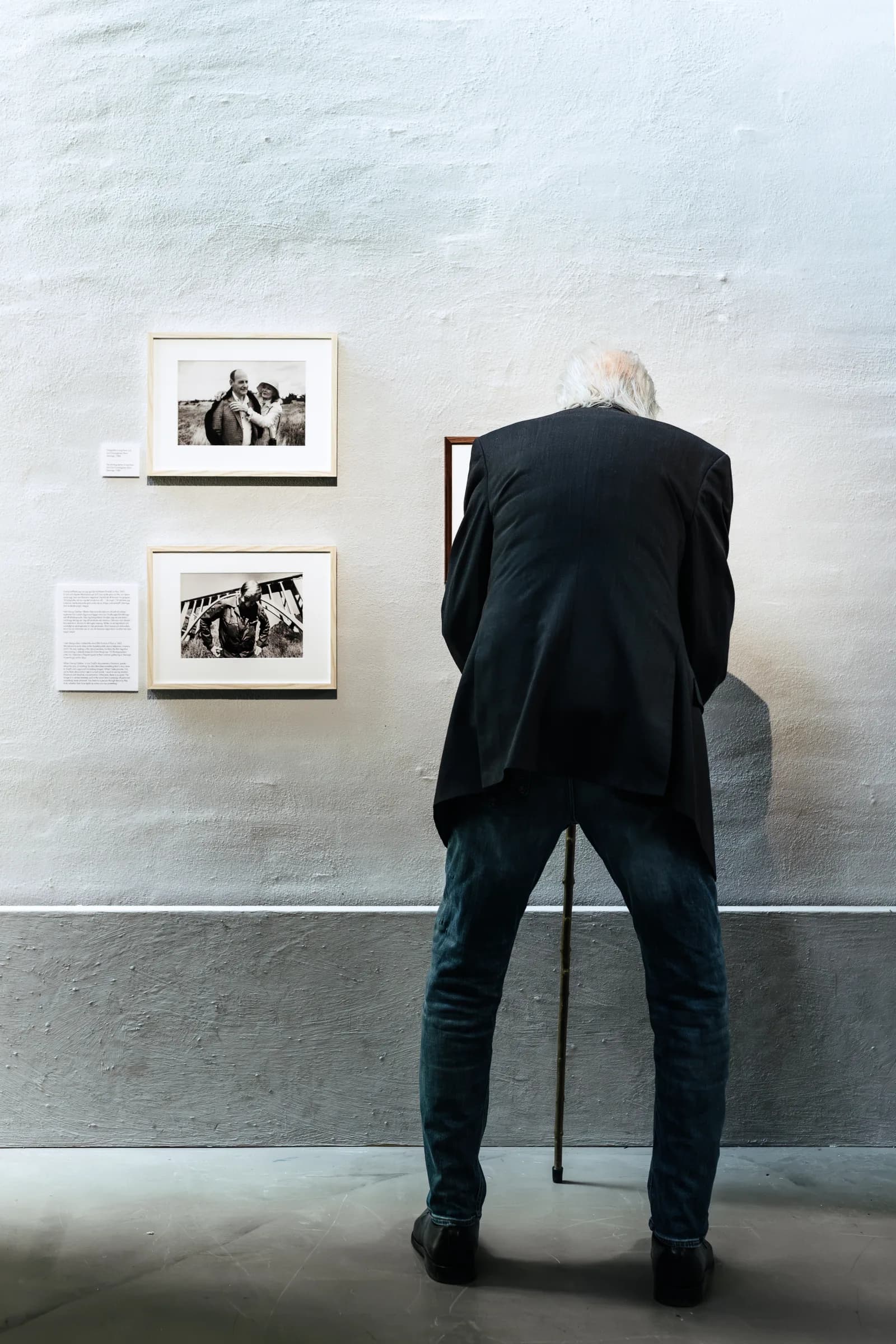 Jan Troell ser på fotografier på sin udstilling