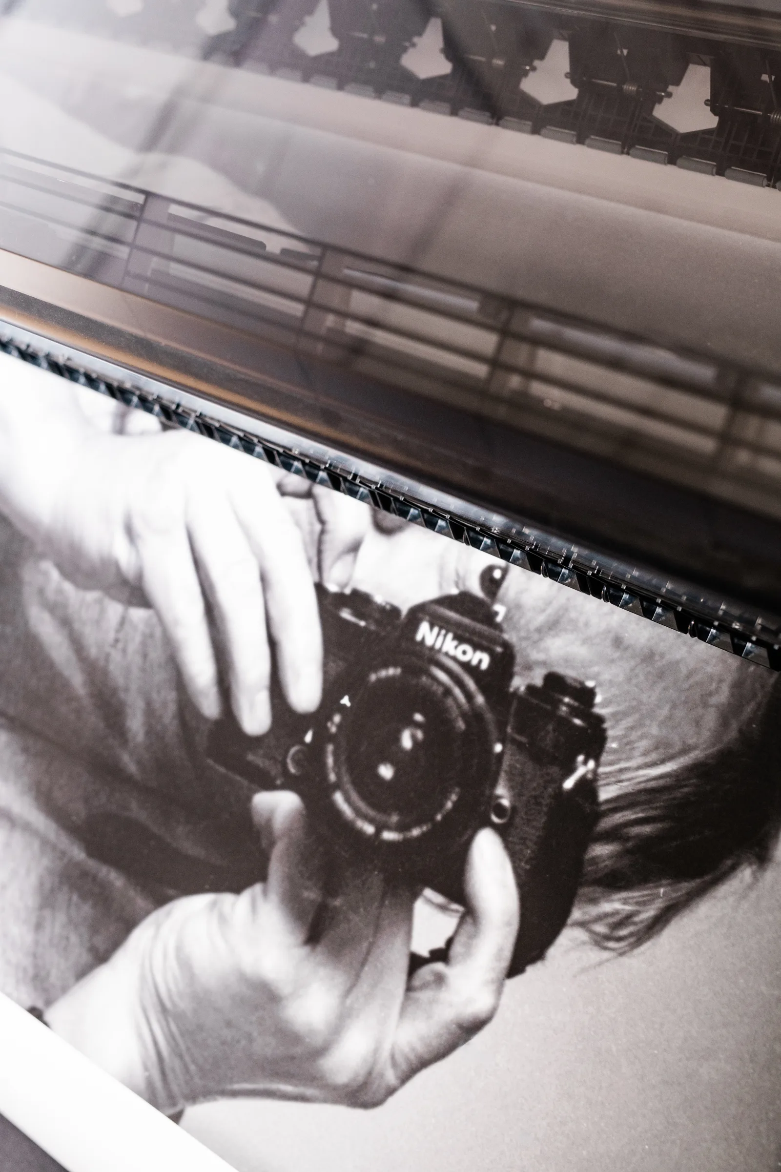 A photograph of Jan Troell holding a camera emerging from the printer