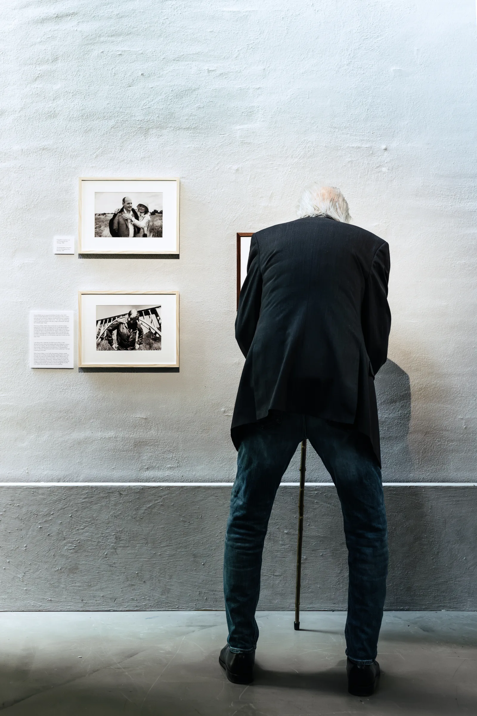Jan Troell viewing photographs in his exhibition